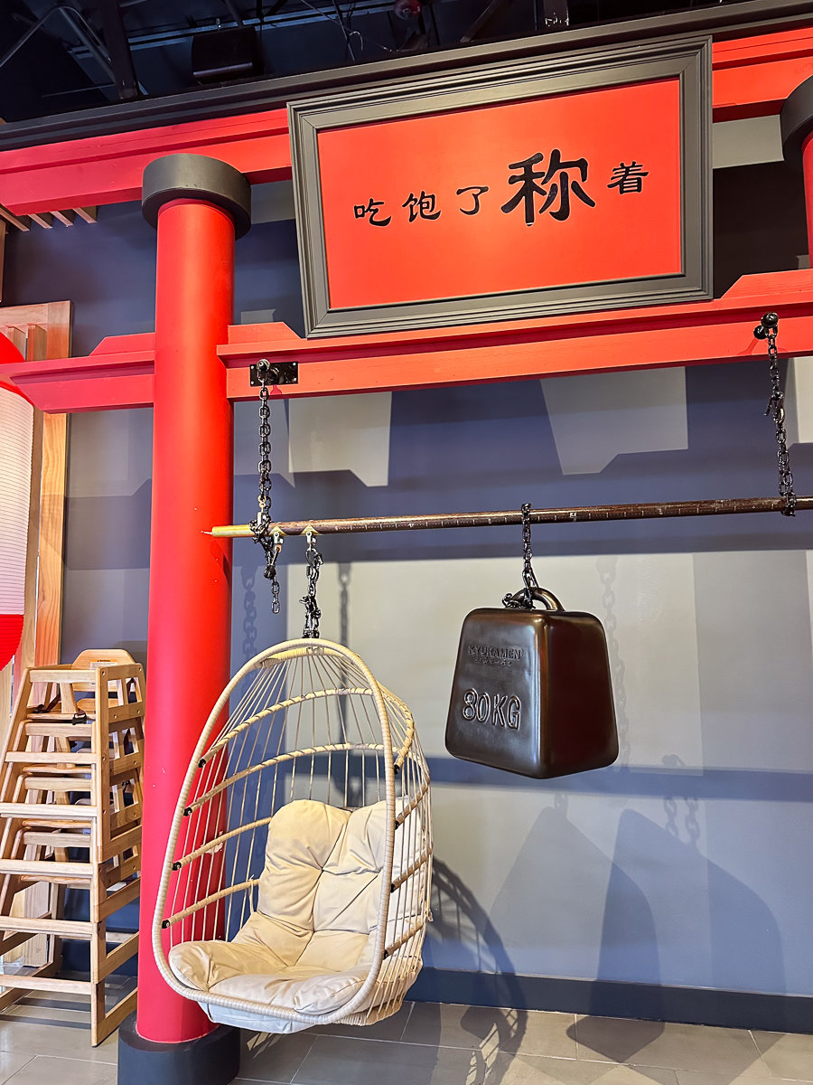 hanging egg chair with a red pole and red japanese sign
